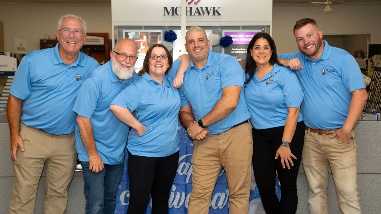 The My Dad's Flooring team posing together at their main office and showroom