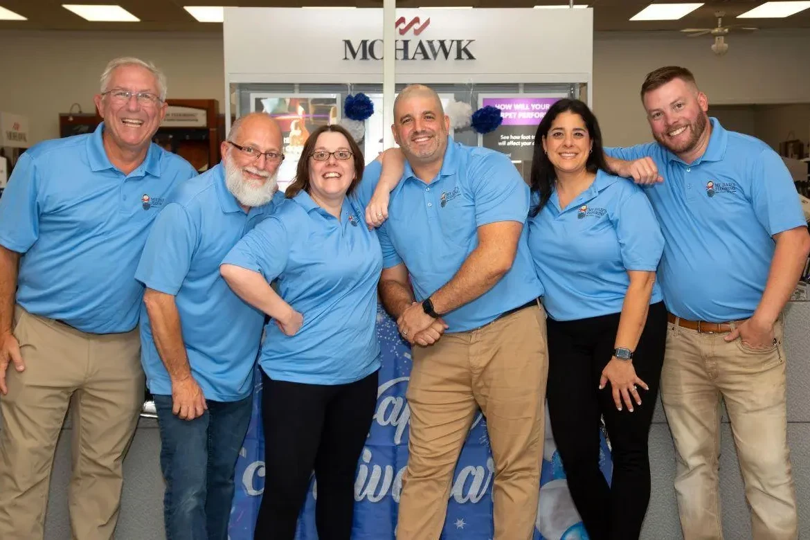 The My Dad's Flooring team posing together at their main office and showroom