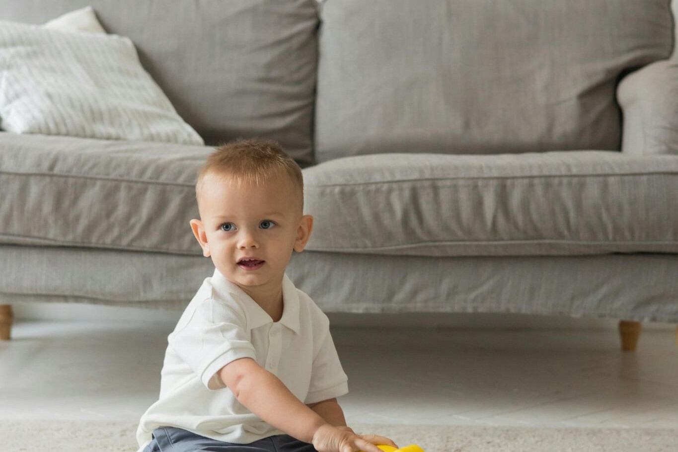 a small child playing wiht a toy on carpet flooring