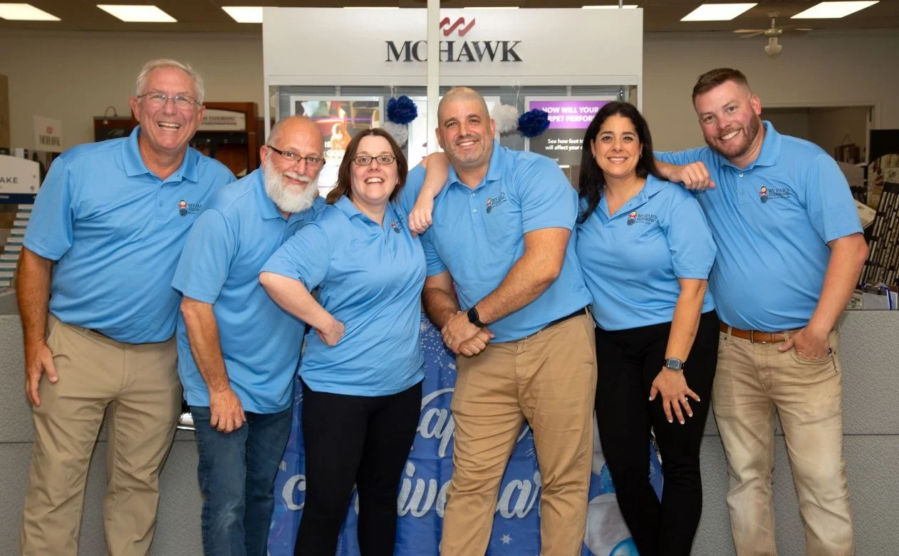 The My Dad's Flooring team posing together at their main office and showroom