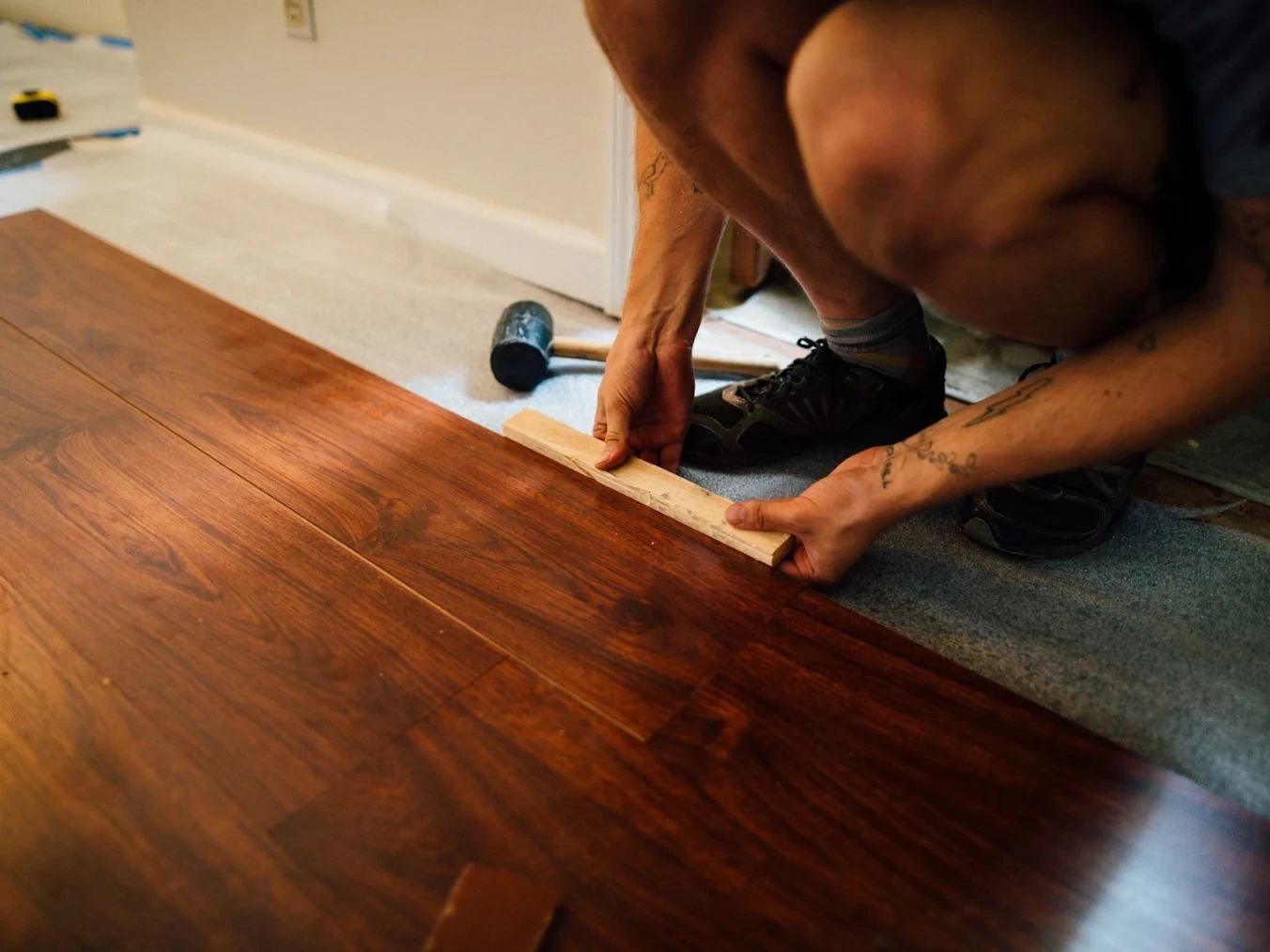 a professional flooring installer installing new hardwood flooring.