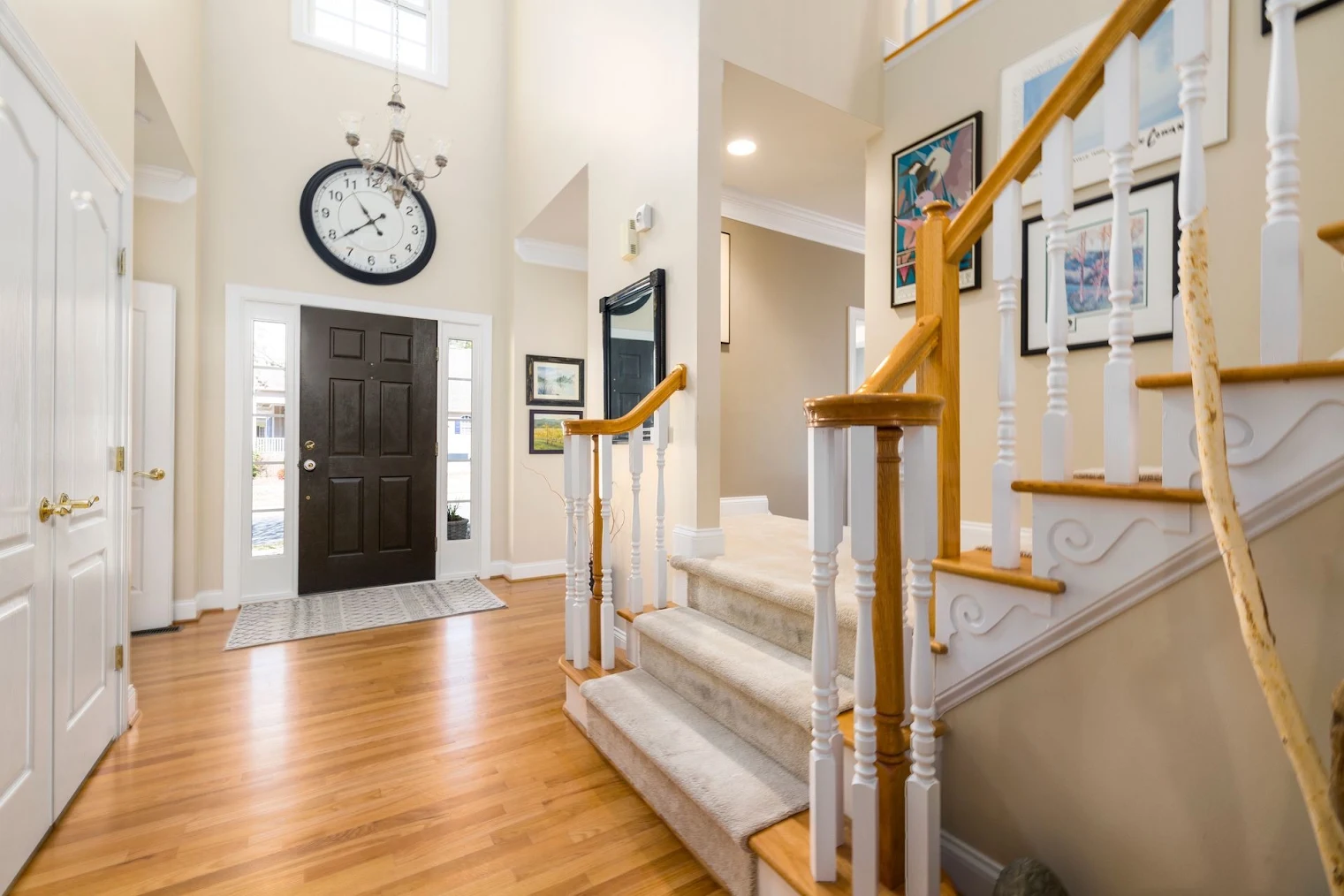 a home entryway with a hardwood staircase with carpet on top.